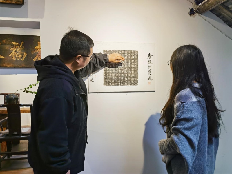 柿闲咖啡馆店主张健向游客讲述店内有关双流的文化古迹.jpg