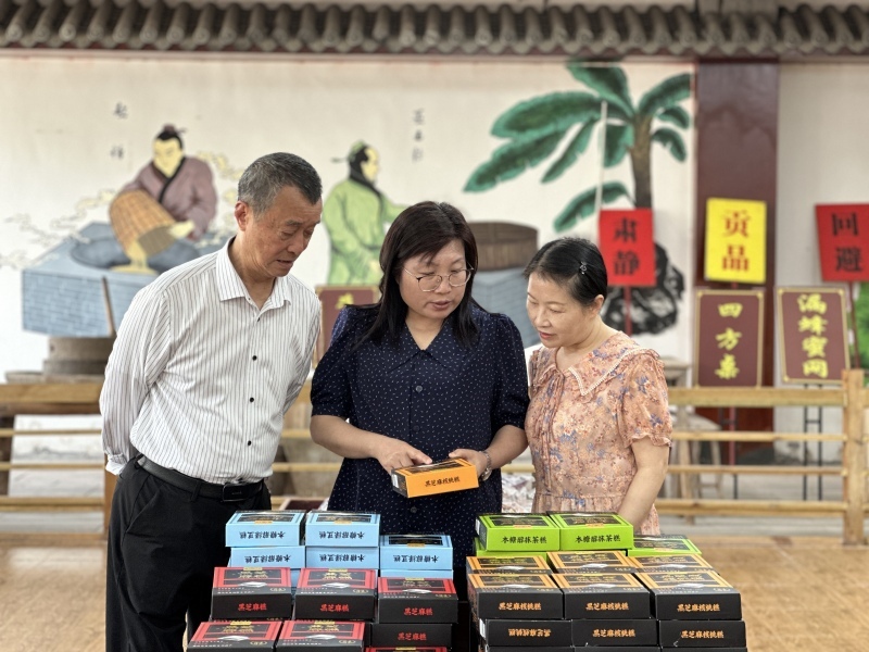 在仁寿县张三芝麻糕食品有限公司，个私协的工作人员正在与企业员工交流.jpg