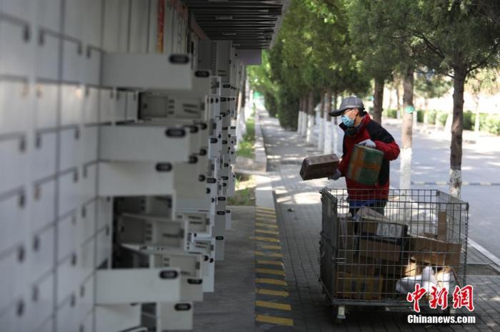资料图：工作人员把快件放入快递柜内。<a target='_blank' href='http://www.chinanews.com/'>中新社</a>记者 蒋启明 摄