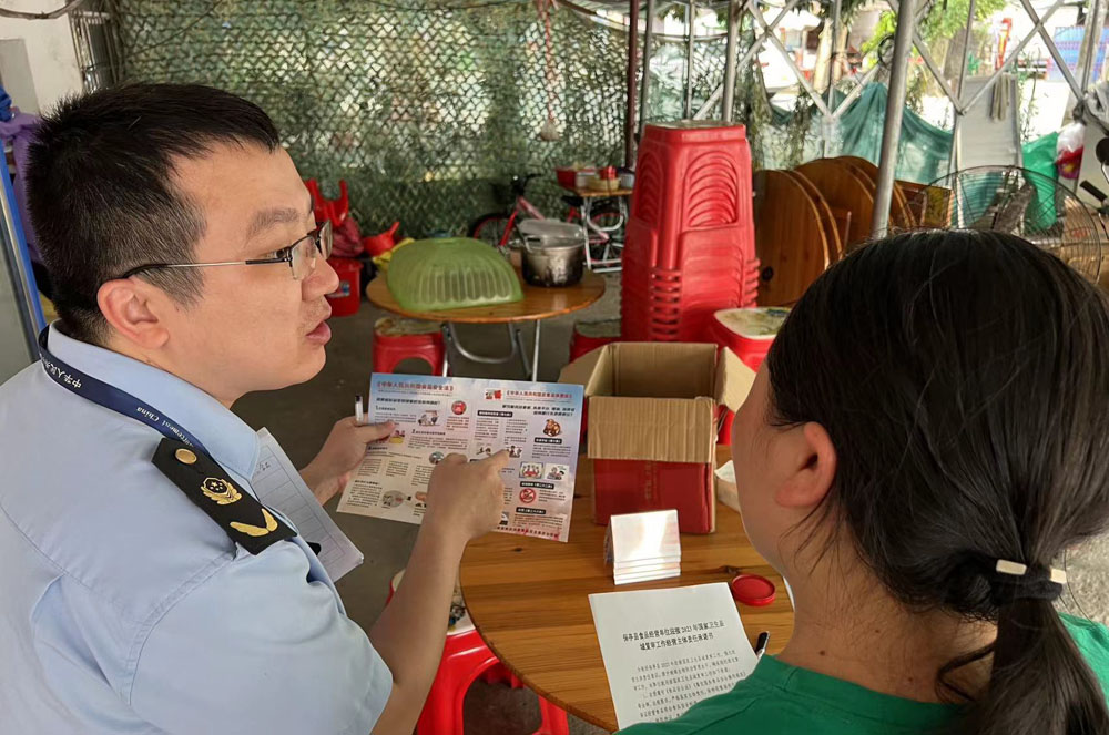 执法人员给餐饮单位宣传相关法律法规.jpg