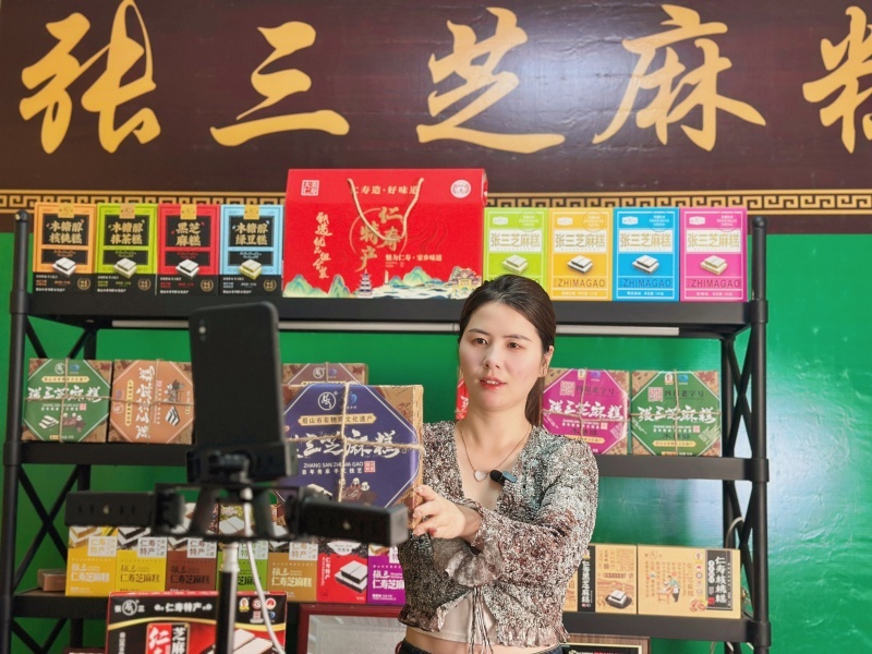 1748230630682943.jpg 在仁寿县张三芝麻糕食品有限公司,工作人员正在直播带货.jpg