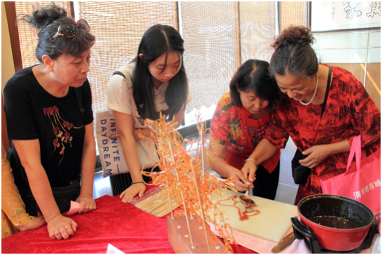 糖画艺人时玉明传授粮画制作技巧(右二)